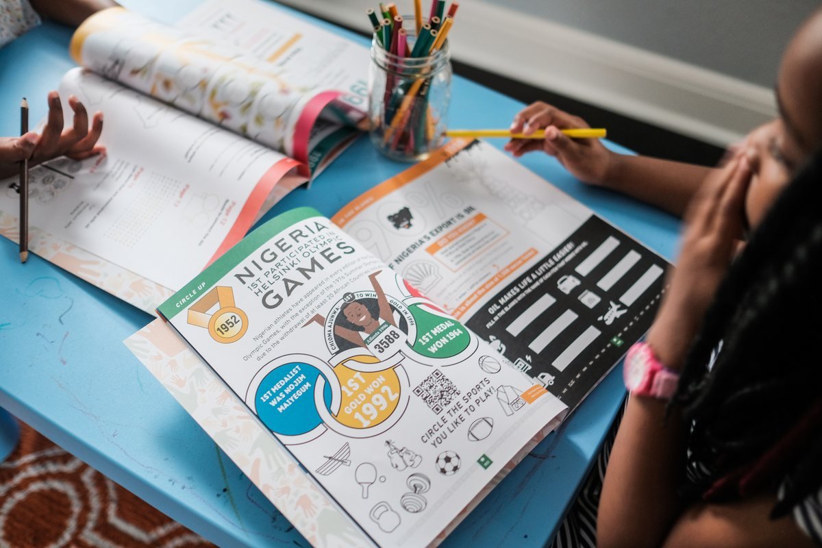 Two children colouring the Olympic Games spread